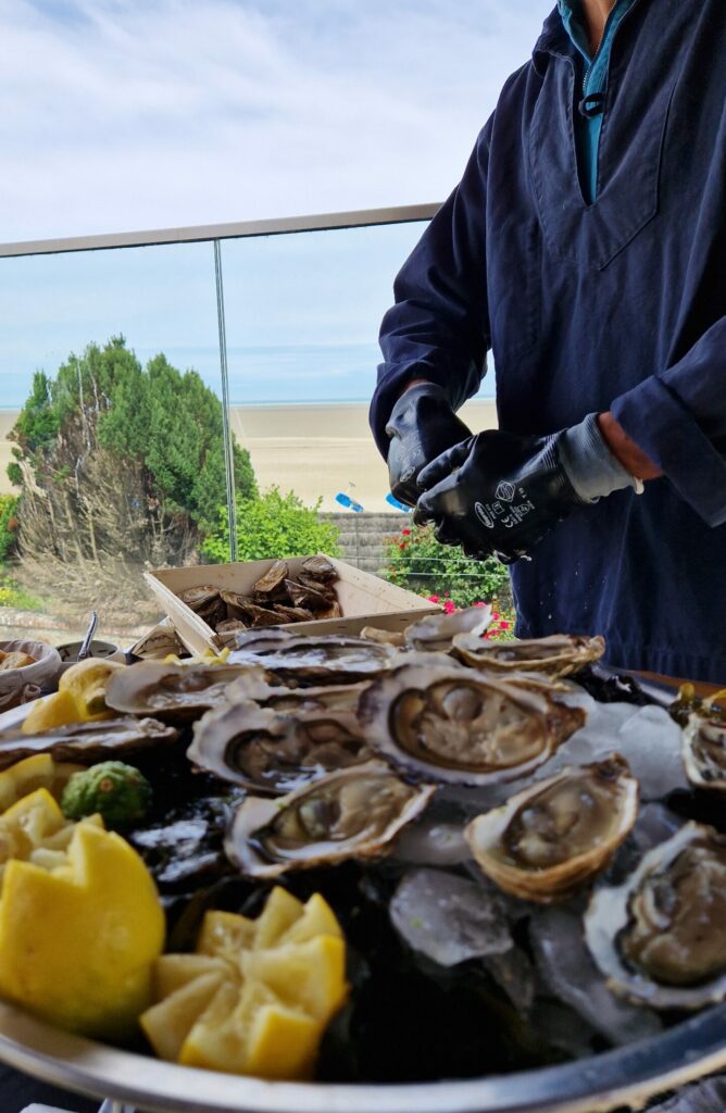 conchyliculteur ouvrant des huîtres pour une dégustation sur le bord de grève