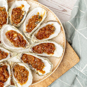 Huitres farcies à l'orientale avec une planche en bois et un torchon bleu très clair